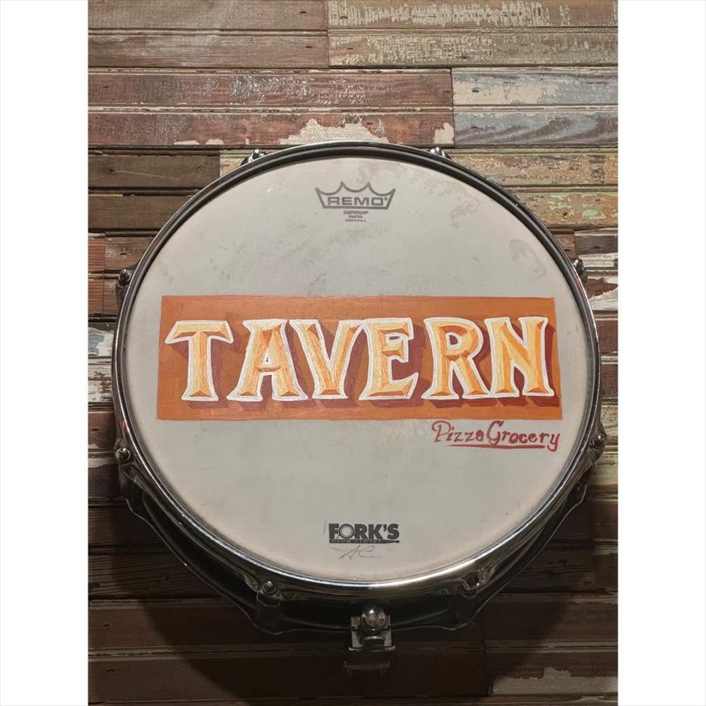 Hand-painted Tavern sign on a drum head at PG Tavern in Corinth, Mississippi