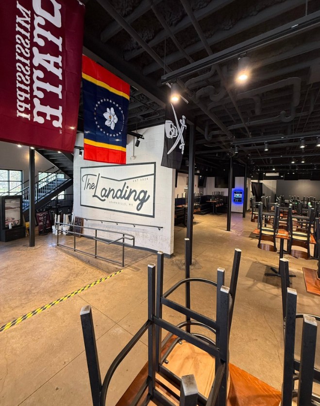 Interior of The Landing in Starkville, Mississippi with flags and a glowing jukebox