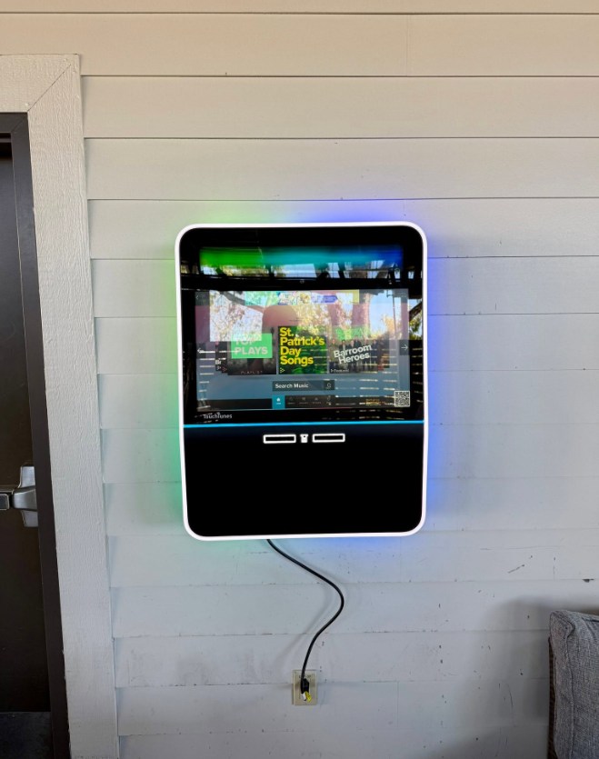 Outdoor wall-mounted TouchTunes jukebox on a covered patio