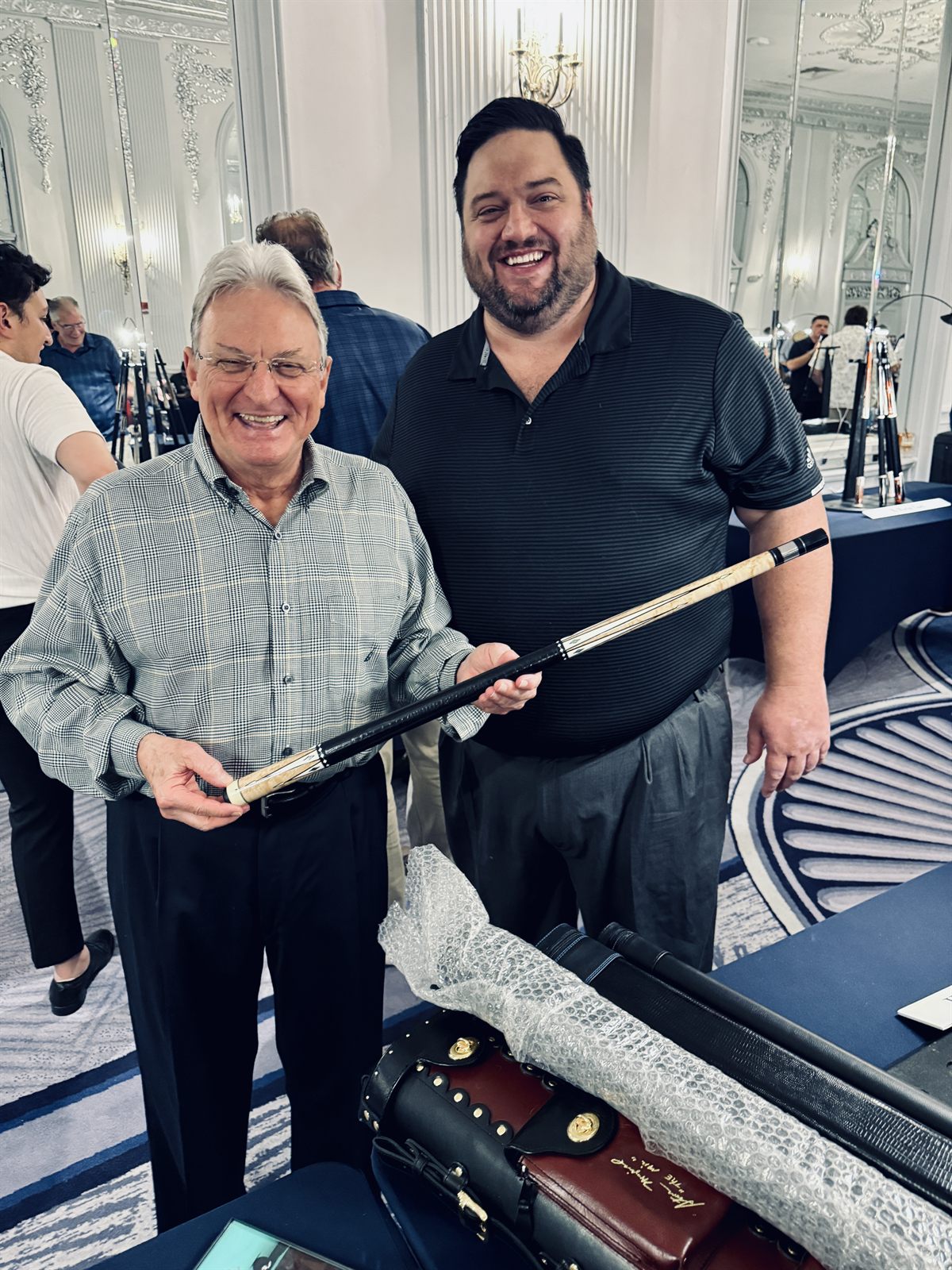 Bill McDaniel and Chase Channell holding a custom pool cue at the ICCS show in Chattanooga, 2025